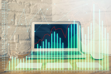 Double exposure of graph and financial info and work space with computer background. Concept of international online trading.