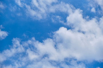 White clouds in the blue sky on a sunny day.