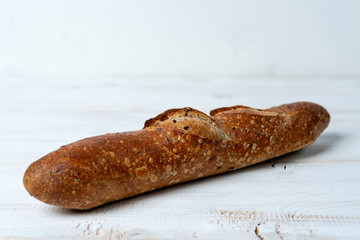 multigrain baguette on white wooden table. Copy space