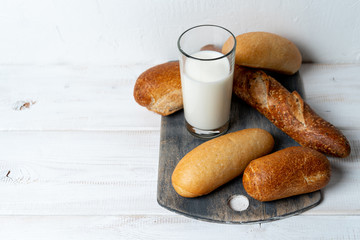 set baguettes with milk. Simple nutritious breakfast. Serve on cutting board.