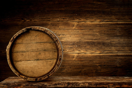 Wooden retro barrel on desk and free space for your decoration. Wall background with shadows. 