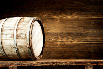 Wooden retro barrel on desk and free space for your decoration. Wall background with shadows. 