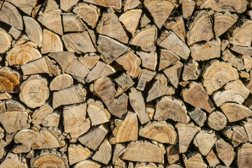 Neatly stacked firewood.  Background of dry chopped logs