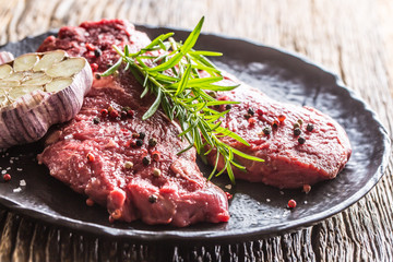 Beef meeat Rib-Eye steak wit rosemary salt and pepper on black plate