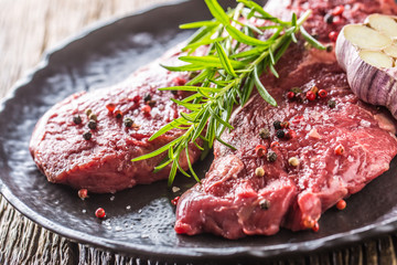 Beef meeat Rib-Eye steak wit rosemary salt and pepper on black plate