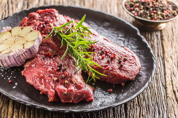 Beef meeat Rib-Eye steak wit rosemary salt and pepper on black plate