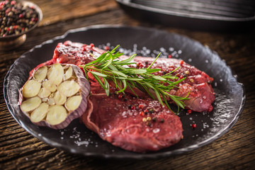 Beef meeat Rib-Eye steak wit rosemary salt and pepper on black plate
