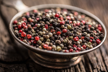 Mixed peppercorns red black and white in bowl - Close-up