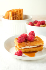 waffles with caramel syrup and raspberries isolated on white background, top view