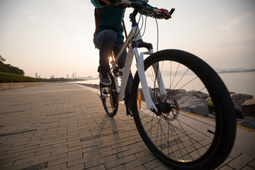 Fototapeta na wymiar Cyclist riding bike in the sunrise coast road