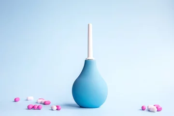 Fototapeten Blue douche and beautiful tablets of pink and white color on a blue background. Medical concept. © amtiko