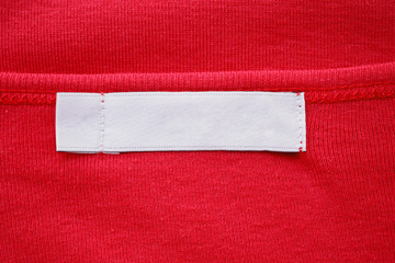 Blank white clothes tag label on new red shirt