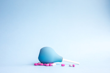 Blue douche lies and pills are pink and white around on a blue background.