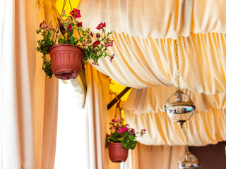 Fototapeta na wymiar Lantern with flowers in the cafe. Summer background.