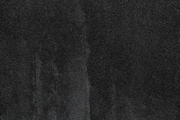 Rustic asphalt dark grainy stone wall background for texture and design backdrop purpose