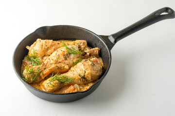 Spicy chicken in a sauce in a frying pan. top view from above