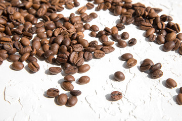 Coffee beans loose on a white textured background. The concept of good morning.