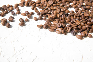 Coffee beans loose on a white textured background. The concept of good morning.