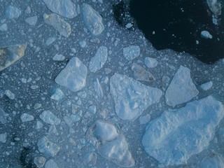 Icebergs drone aerial image top view - Climate Change and Global Warming. Icebergs from melting glacier in icefjord in Ilulissat, Greenland. Arctic nature ice landscape in Unesco World Heritage Site.