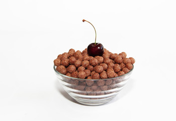 corn chocolate sweet balls in a glass plate and cherry berries on a white background