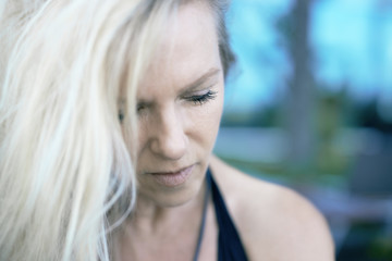 Attraktive reife Frau mit blonden Haaren in Gedanken versunken