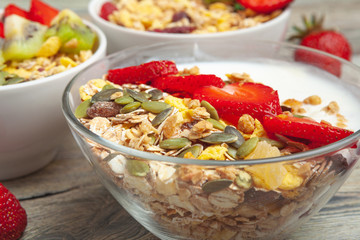 Healthy breakfast with yogurt, berries and granola on wooden table top view