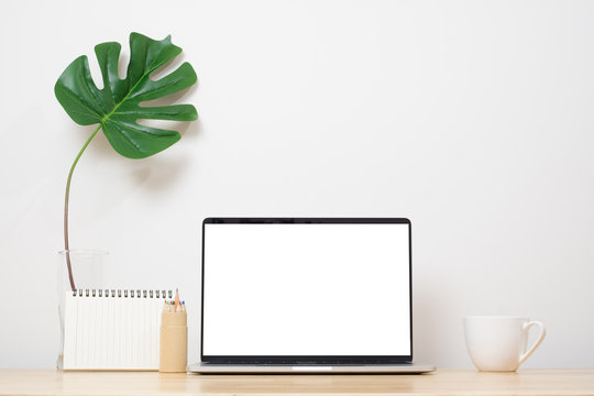 Laptop computer blank sreen on desk and coffee cup. Desk minimal style.