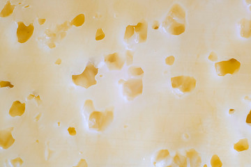 Cheese texture close up. Yellow surface with small caves and holes. Macro. Background for postcard about diary manufacture, agriculture, natural food, Horizontal with copy space