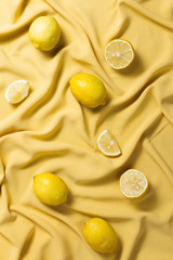 Flatlay of lemons lying on yellow fabric