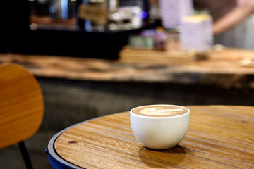 Cappuccino coffee on wooden table in coffee shop