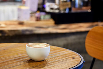 Cappuccino coffee on wooden table in coffee shop