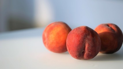 Few fresh red peaches at light surface