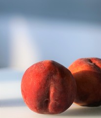 Few fresh red peaches at light surface