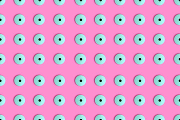 Creative seamless hypnotic pattern of googly eyes candy in vibrant bold holographic neon colors on pastel pink background in pop-art style.Photography collage.Halloween holiday concept.