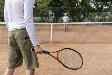 Couple playing tennis on court