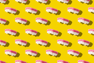 Photography collage of gummy milk teeth or jelly candies on bold yellow background top view flat lay isometric seamless pattern.Funny children's treats.Halloween holiday concept.surrealism,pop-art 