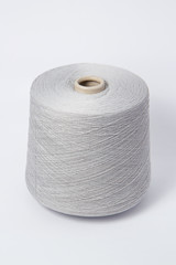 Green bobbin of yarn on a white background.Textile reel on isolated white background.