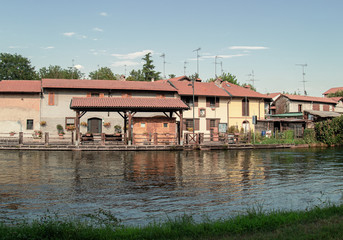 houses and vegetable gardens on the canal in the countryside outside Milan