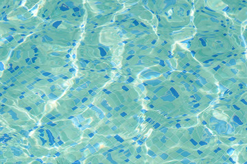 Blue bright water in swimming pool with sun reflection. Ripple water texture