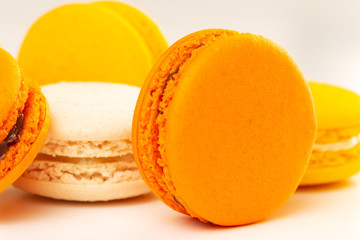 Orange and yellow macarons or macaroons stacked. Closeup.