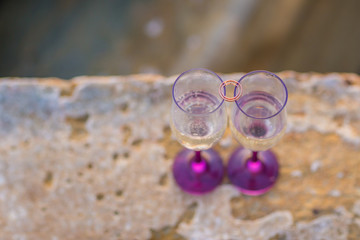 Champagne glasses with engagement Jewelry in front of aea background