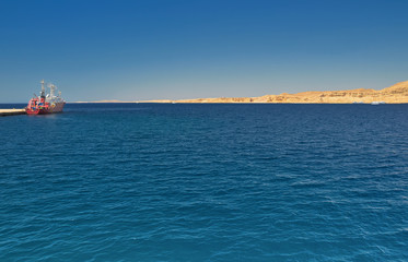 ship docked at the pier wall in port, amid open sea