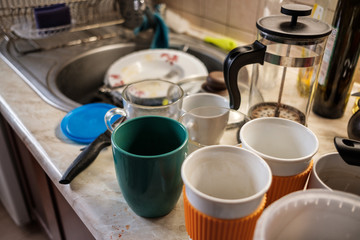 Obraz na płótnie Canvas Loads of dirty dishes stacked around the sink in the kitchen