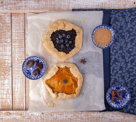 Summer sweet pie cake galette with  blueberry and mango on rustic wooden background. Top view