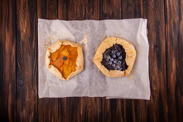 Summer sweet pie cake galette with mango and blueberry over on wooden background. Top view