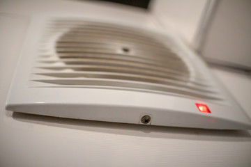 Fototapeta premium Close-up of a white range hood with an indicator on the wall in the bathroom