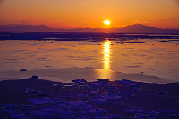 sunrise over sea filled with drift ice