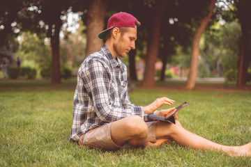 young male freelancer working on a tablet and typing the text
