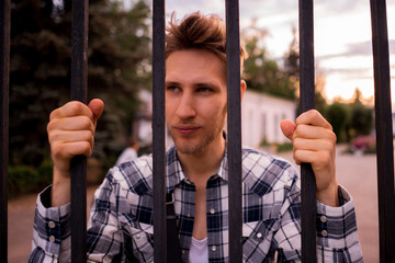 close up dispair man standing next to the cell looking at the city freedom life