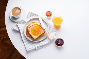 Morning toasts with butter and confiture on white table